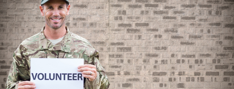 Soldier holding a 'volunteer' placard
