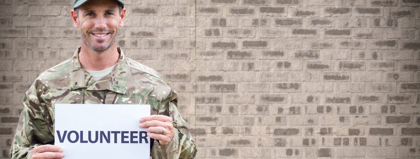 Soldier holding a 'volunteer' placard