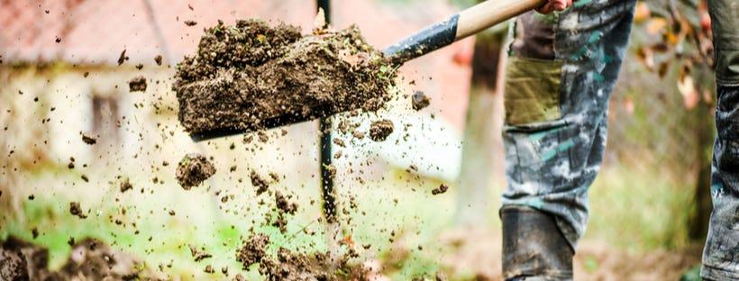 Worker digging soil with a shovel