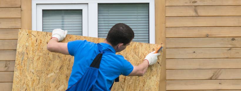 Man boarding up window