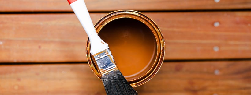 Open can of paint on wooden deck