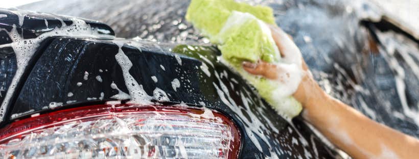 Cleaning car with soap and sponge